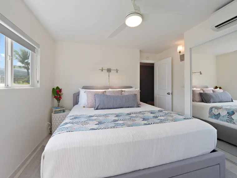 Second bedroom with queen bed, ceiling fan, and garden view