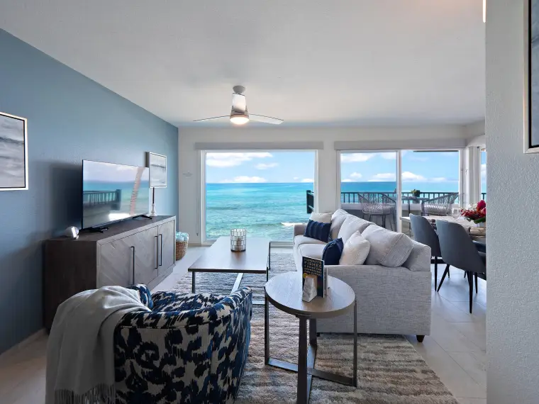 Open-plan living room with blue accent wall and panoramic ocean views
