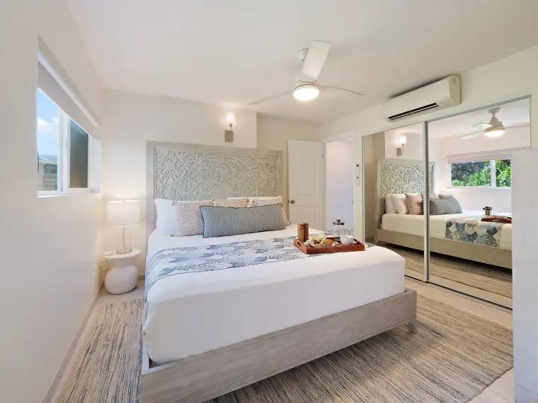 Primary bedroom with carved headboard, king bed, and ceiling fan